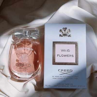 Sophisticated perfume bottle and box displayed on soft fabric with natural light.